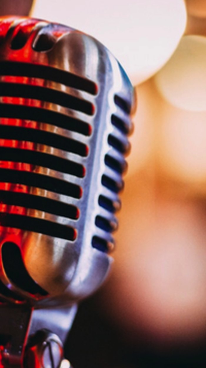 Vintage silver vocal microphone under stage lights